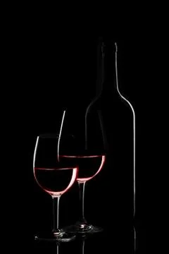 Red wine bottle and two wine glasses on black background on black background Stockfoto's