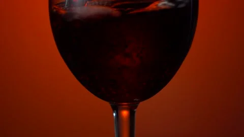 Red wine forms beautiful wave. Wine pouring in wine glass over white background Stock Footage 153467913