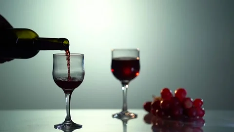 Red wine forms beautiful wave. Wine pouring in wine glass over black background Stock Footage 153526179