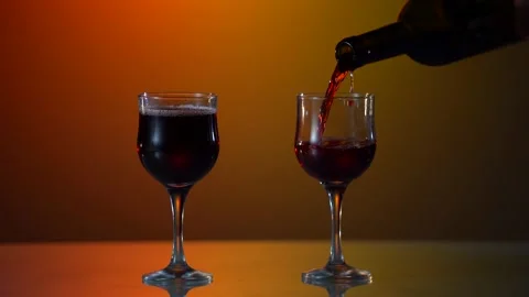 Red wine forms beautiful wave. Wine pouring in wine glass over white background Stock Footage 154303214