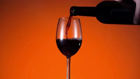Red wine forms beautiful wave. Wine pouring in wine glass at dramatic background Stock Footage 155792432