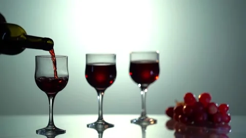 Red wine forms beautiful wave. Close-up shot. Wine pouring in wine glass over Stock Footage 156518073