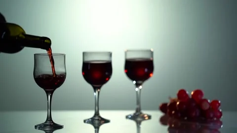 Red Wine. Fresh red grape lay on the glass reflected surface on the white Stock Footage 153351248