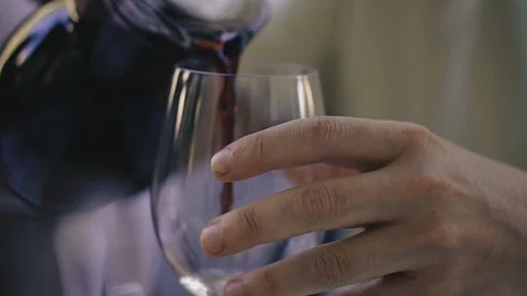 Red wine. A hand pours red wine from a jug into a glass. Stock Footage 123174178