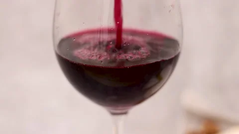 Red wine pour flows from bottle in glass gray tiles background Stock Footage 239303158