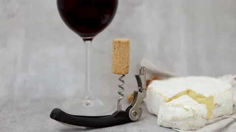 Red wine pour flows from bottle in glass gray tiles background Stock Footage 239303207