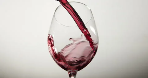 Red wine is poured from bottle into wine glass Stock Footage