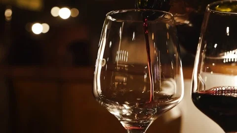 Red wine is poured into a glass Stock Footage