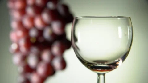 Red wine is poured into a glass on a light background. Stock Footage 83725458