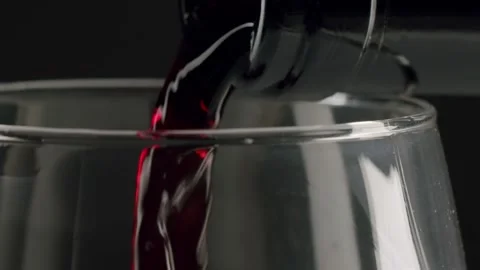 Red wine pouring into a glass in slow motion Stock Footage 329281175