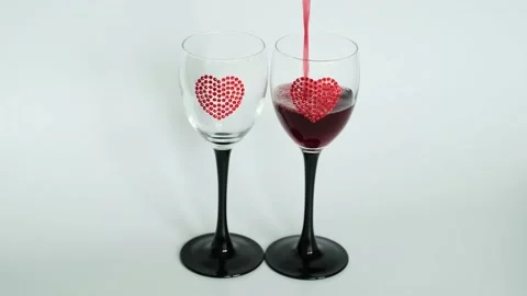 Red wine pouring into goblets decorated with hearts on white background. Stock Footage 169226609
