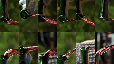Red wine pouring from the neck of a bottle against the backdrop of nature. Stock Footage 281119520