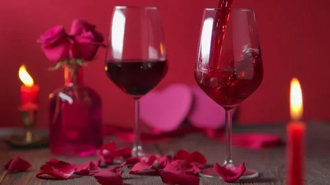Red wine pouring into a stemware glass on a rustic wooden table Video stock 330790702