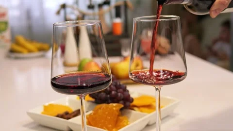 Red wine pours gracefully from the bottle into the glass, the ruby liquid Stock-Footage 273030528