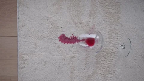 Red wine spilled on beige carpet from overturned glass creates deep crimson.. Stock Footage 331900487