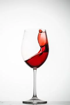 Red wine splashes in a glass Stock Photos