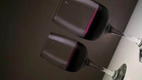 Red wine in two glasses on a light table. The camera turns 360. Slow motion. Stock Footage 146640465