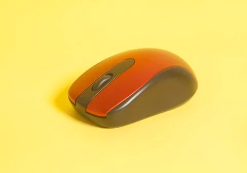 Red wireless computer mouse on yellow background Fotos Stock