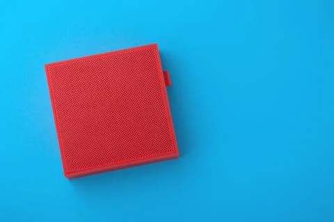 Red wireless speaker on blue background, minimalism, flat lay Stock Photos