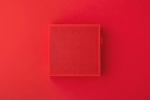 Red wireless speaker on red background, minimalism, flat lay Stock Photos