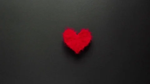 Red woolen heart pulsing on the black background_1 Stock Footage 72285357