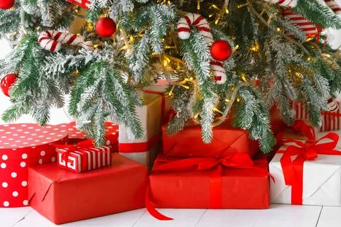 Red wrapped gift boxes, presents under festive Christmas tree with lights a.. Stock Photos