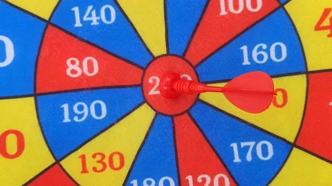 Red, yellow and red colored dartboard rotating and dart hitting in the center Stock Footage 209339797