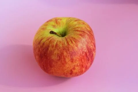 Red yellow apple on a pink background. Juicy ripe beautiful fruit Stock Photos