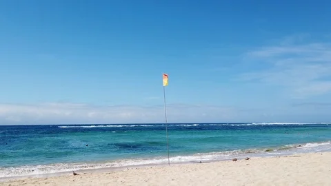 Red-yellow flag on the beach near the water Stock Footage 108720587