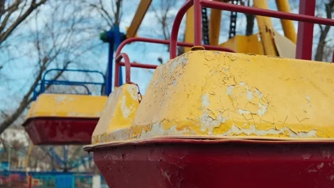 Red-yellow lonely empty deserted swing in an old abandoned amusement park Stock Footage 151924433
