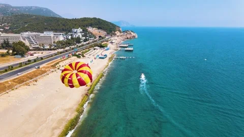 The red-yellow parachute is shading behind the boat. Parasailing in Vídeo Stock 194166018