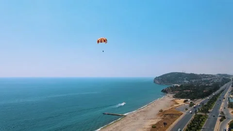 The red-yellow parachute is shading behind the boat. Parasailing in Vídeo Stock 194166061