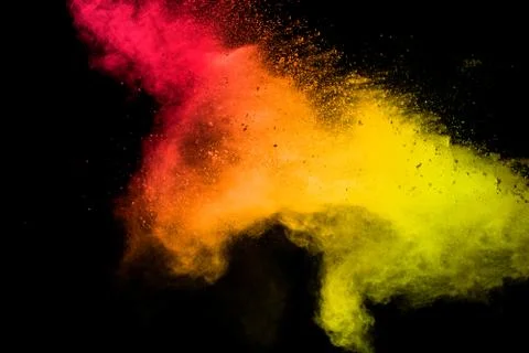 Red yellow powder explosion cloud on black background. Stock Photos