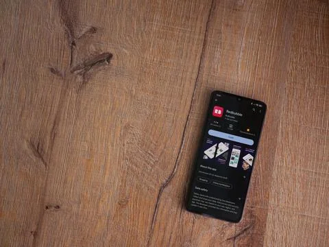 Redbubble app play store page on smartphone on wooden background Stock Photos