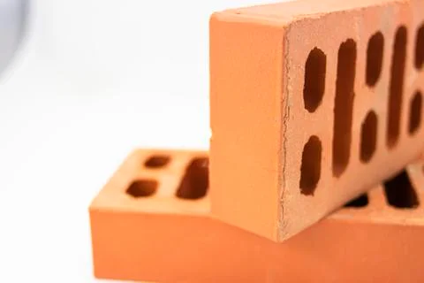 Reddish bricks of perforated building construction and face view Stock Photos