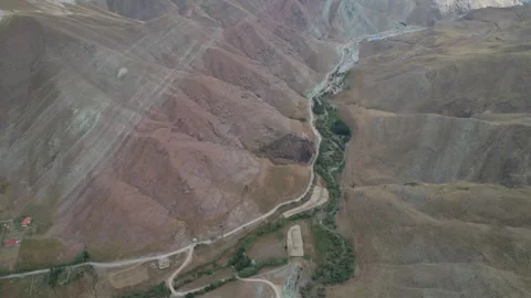 Reddish brown Chalus Road mountains frame a narrow green drainage line, Stock Footage 343907355