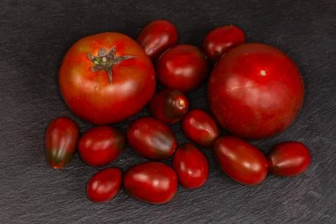 Reddish brown small plum tomatoes and big round tomatoes Stock Photos