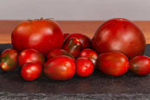 Reddish brown small plum tomatoes and big round tomatoes Stock Photos