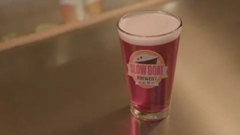 Reddish Draft Beer Served in Glass on Bar Counter at Beijing Brewery, China Stock Footage 345757813