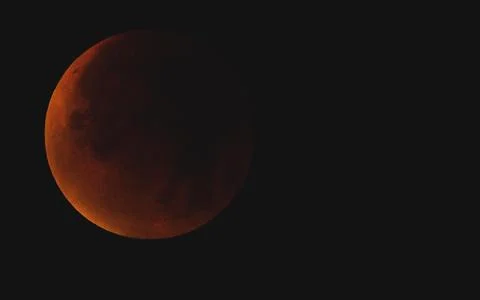 A reddish moon during a total lunar eclipse in the dark night sky, Haan, North Stock Photos