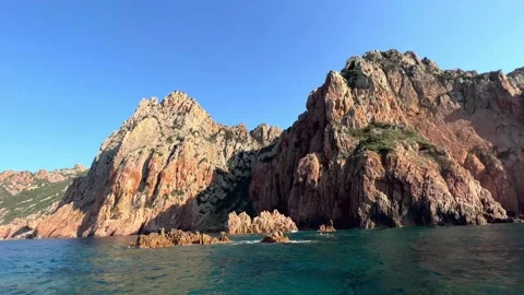 Reddish orange rocks of calanques de piana seen from tour boat on mediterranean Video stock 277521127
