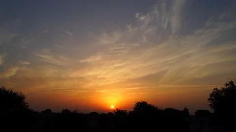 Reddish sunbeams with sunset. Horizontal closeup of sun hiding in cloudy sky. Stock Footage 148203616