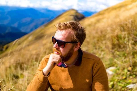 Redhaired ginger beard man resting in hills landscape in summer day Stock Photos
