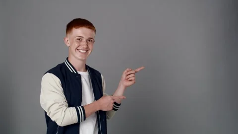 Redhead boy looking at camera and pointing on copy space Stock-Footage 244699104