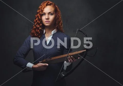 Redhead female holds crossbow. Stock Photos