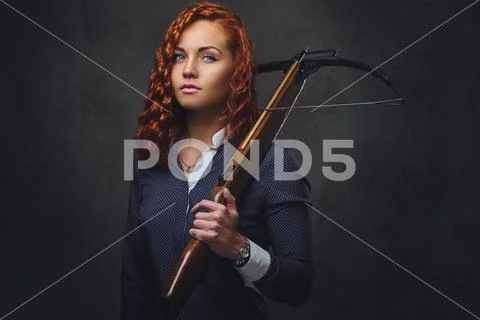 Redhead female holds crossbow. Stock Photos