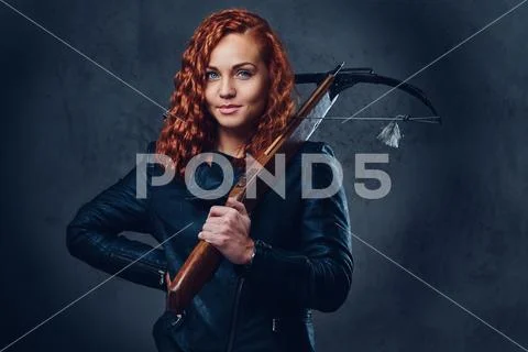 Redhead female holds crossbow. Stock Photos