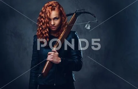 Redhead female holds crossbow. Stock Photos