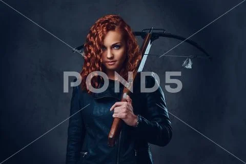 Redhead female holds crossbow. Stock Photos