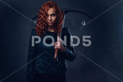 Redhead female holds crossbow. Stock Photos
